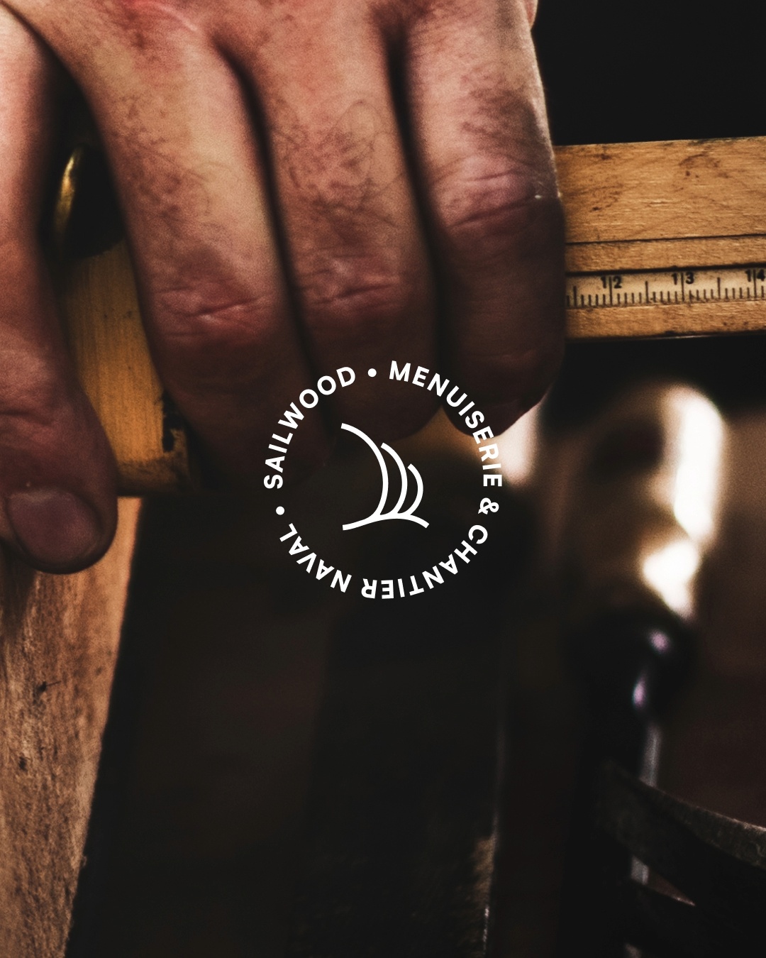 Main d’artisan travaillant le bois, estampille Sailwood menuiserie et chantier naval